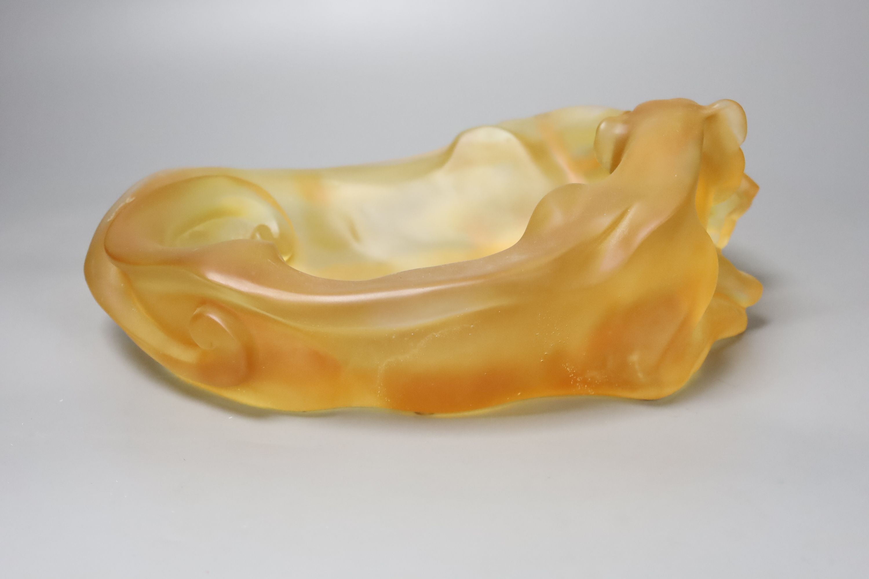 An amber glass dish with a recumbent lioness, signed, 24cm wide, apocryphal Daum mark